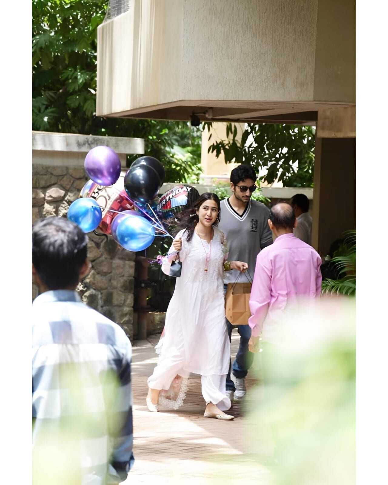 Sara was dressed in a white ethnic outfit and had balloons in her hand. Ibrahim followed her